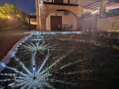 a garden with lights in the yard at night at Villa Mare in Kiotari