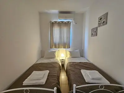 two beds in a small room with a window at Villa Mare in Kiotari