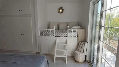 a white room with a shelf and a bed at Feraklion House in Haraki
