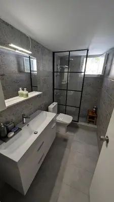a bathroom with a sink and a toilet and a mirror at Feraklion House in Haraki