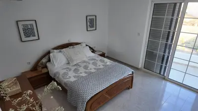 a bedroom with a bed and a large window at Feraklion House in Haraki