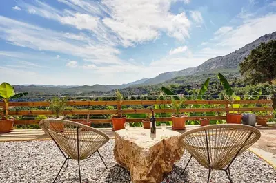a patio with a table and chairs and mountains at Valley View Studio Apartment Salakos in Sálakos