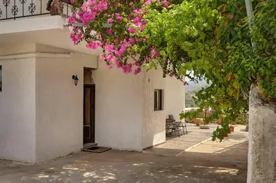 a white building with pink flowers on it at Valley View Studio Apartment Salakos in Sálakos