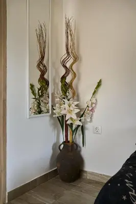 a vase with flowers in it next to a wall at Valley View Studio Apartment Salakos in Sálakos