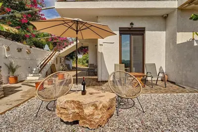 a table with an umbrella and two chairs and a table with a rock at Valley View Studio Apartment Salakos in Sálakos