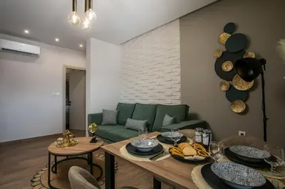 a living room with a green couch and a table at Maro Luxury Villa in Afantou