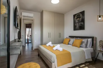 a bedroom with a large bed with yellow pillows at Maro Luxury Villa in Afantou