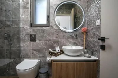 a bathroom with a sink and a toilet and a mirror at Maro Luxury Villa in Afantou