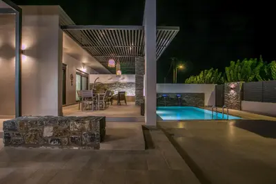 a house with a swimming pool at night at Maro Luxury Villa in Afantou