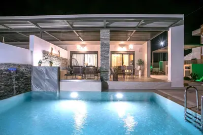 a large swimming pool in a house at night at Kiki Luxury Villa in Afantou