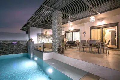 a house with a swimming pool and a dining room at Kiki Luxury Villa in Afantou