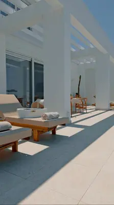 a patio with benches and tables on a building at Seapalm Villa - Elegant Stay - Steps from the Sea in Lachania