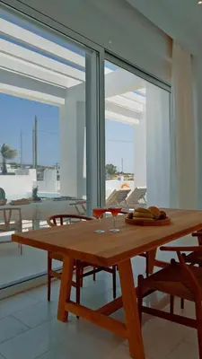 a wooden table with two glasses on top of a room at Seapalm Villa - Elegant Stay - Steps from the Sea in Lachania