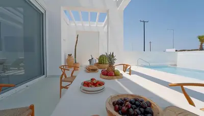 a room with bowls of fruit on a table next to a swimming pool at Seapalm Villa - Elegant Stay - Steps from the Sea in Lachania