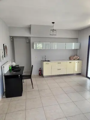 a kitchen with a sink and a table in a room at Grande casa di Ialysos in Ixia