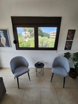 two chairs and a table in a room with a window at Grande casa di Ialysos in Ixia