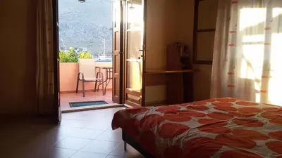 a bedroom with a bed and a door to a balcony at Pedi Breeze in Symi
