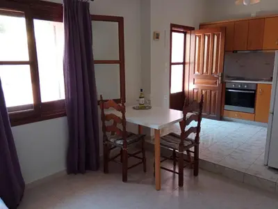 a kitchen with a table and chairs in a room at Pedi Breeze in Symi