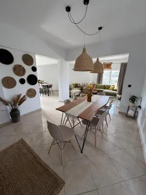 a dining room and living room with a table and chairs at Jojo's Home in Kamiros