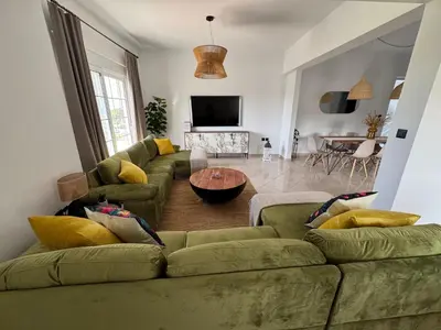 a living room with a green couch and a table at Jojo's Home in Kamiros