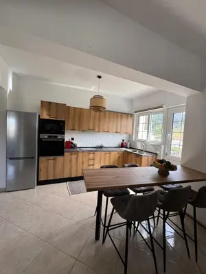 a kitchen with a wooden table and a stainless steel refrigerator at Jojo's Home in Kamiros