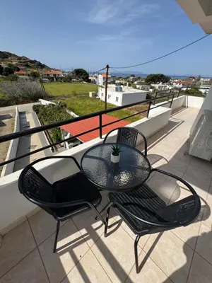 a table and two chairs sitting on a balcony at Jojo's Home in Kamiros