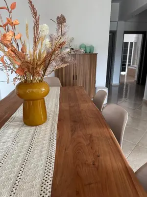 a wooden table with a vase with flowers in it at Jojo's Home in Kamiros