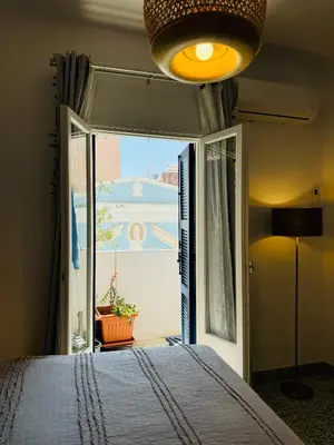 a bedroom with a bed and a large window at Aelios City House in Rhodes Town