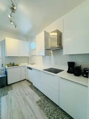 a white kitchen with white cabinets and a sink at Aelios City House in Rhodes Town