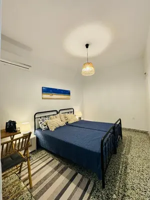 a bedroom with a bed with a blue comforter at Aelios City House in Rhodes Town