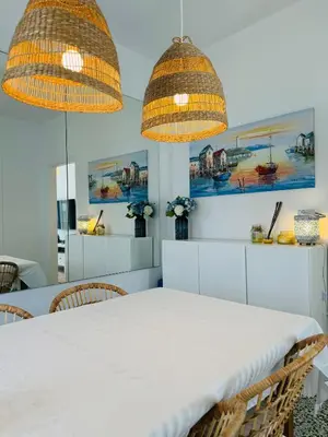 a dining room with a white table and two lights at Aelios City House in Rhodes Town