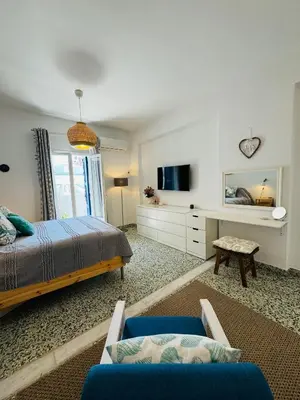 a bedroom with a bed and a tv and a couch at Aelios City House in Rhodes Town