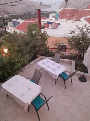two tables and chairs on a patio with a view at Sevasti Symi Studios in Symi