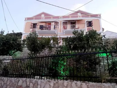 a pink house on top of a wall at Sevasti Symi Studios in Symi