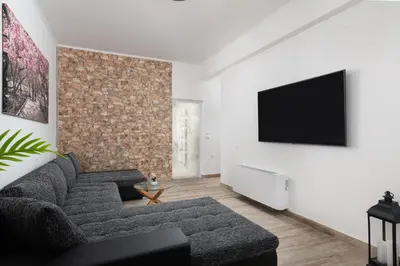 a living room with a couch and a flat screen tv at Sun Dream Apartment in Rhodes Town