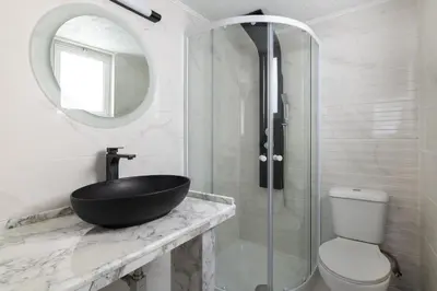 a bathroom with a black sink and a shower at Sun Dream Apartment in Rhodes Town