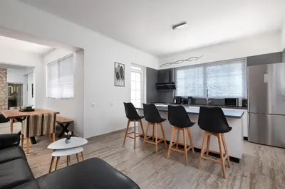 a kitchen and living room with a table and chairs at Sun Dream Apartment in Rhodes Town