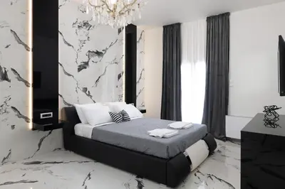 a black and white bedroom with a bed and a chandelier at Sun Dream Apartment in Rhodes Town