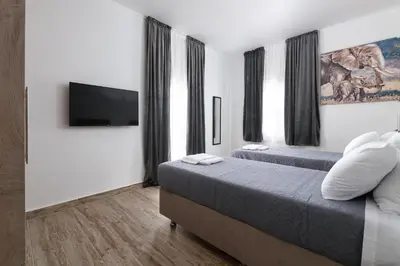 a bedroom with two beds and a flat screen tv at Sun Dream Apartment in Rhodes Town