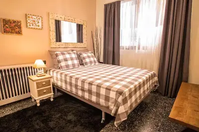a bedroom with a bed with a plaid blanket and a window at Cozy near the sea-Sunset View Apartments in Ixia