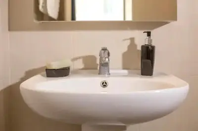a white bathroom sink with a soap dispenser on it at Cozy near the sea-Sunset View Apartments in Ixia