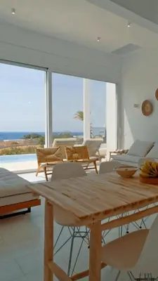 a dining room with a wooden table and chairs at Seadream - Luxury Villa - Pool & Sea View in Lachania