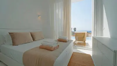 a white bedroom with a bed with towels on it at Seadream - Luxury Villa - Pool & Sea View in Lachania