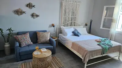 a bedroom with a bed and a blue couch at Ariadne in Halki
