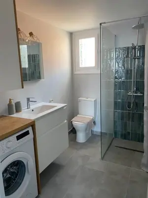 a bathroom with a toilet and a sink and a washing machine at Ariadne in Halki