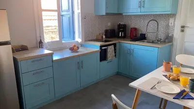 a kitchen with blue cabinets and a table at Ariadne in Halki