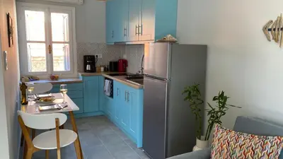 a kitchen with blue cabinets and a stainless steel refrigerator at Ariadne in Halki
