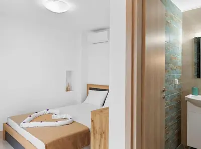 a small bedroom with a bed and a sink at VaStekaHouse in Haraki