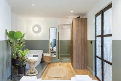 a bathroom with a tub and a mirror at Zerania Suites in Rhodes Town