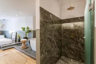 a bathroom with a shower and a bathtub at Zerania Suites in Rhodes Town